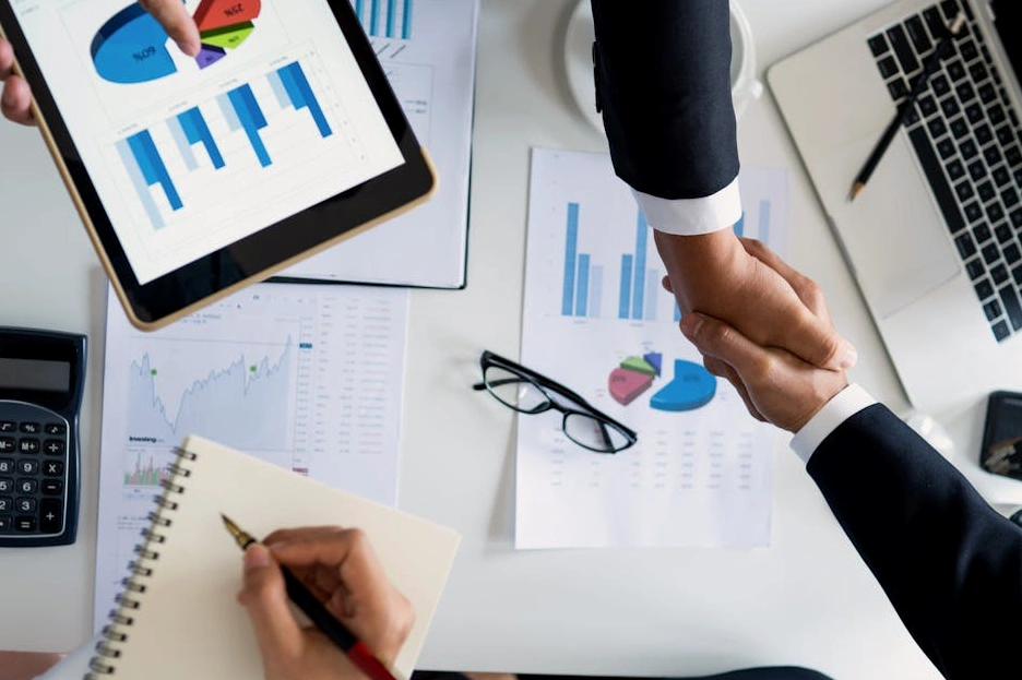 Profesional sonriendo mientras analiza gráficos de rendimiento en un portátil